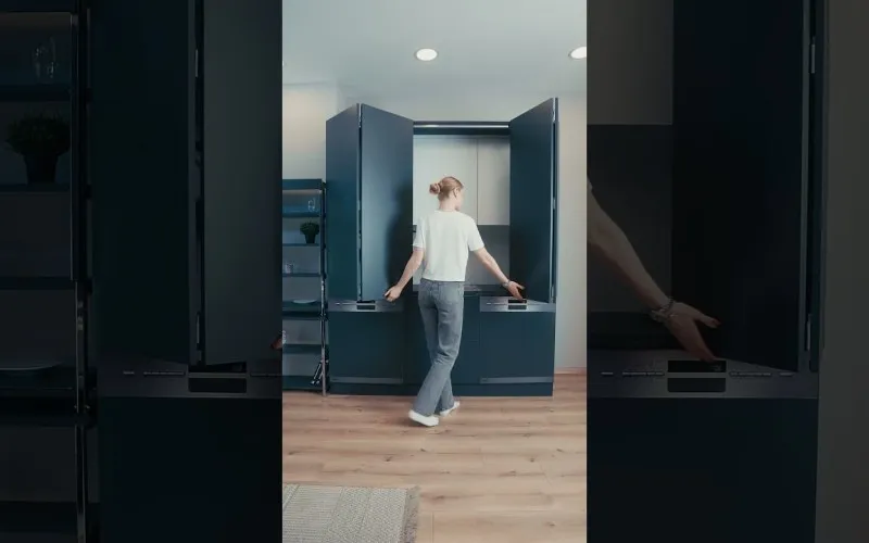 Secret Kitchen | Video Description: A presenter opens a compact cabinet unit and demonstrates how it unfolds into a complete kitchen with worktop, sink, cooktop and storage, then closes it back into a flush cabinet front - a smart kitchen that creates space for those who say there is no room at home.